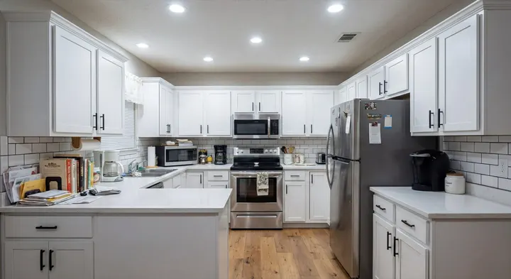AI design of the same kitchen: white shaker cabinets, subway tile backsplash, light wood floor